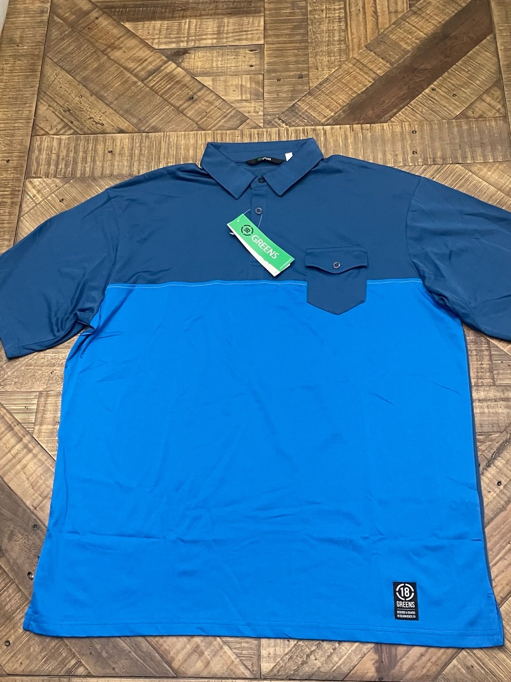 a two-tone blue 18 Greens golf polo shirt